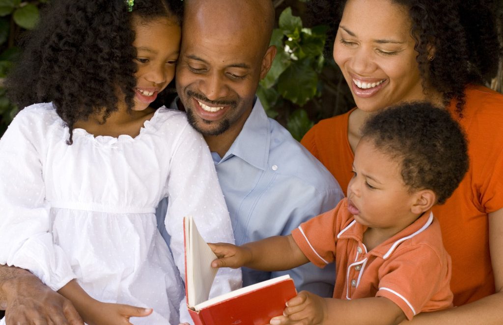 Happy African American parents and their children. - improving children's reading