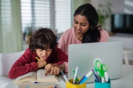 A mother helping her child with writing.