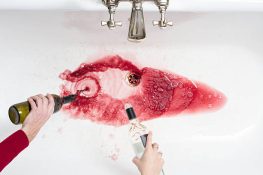 Overhead shot of wine being poured away in an act of quitting alcohol