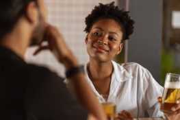 A lady drinking a glass of beer with a friend