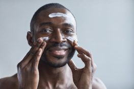 A man-applying-skin care produce on-his-face (for men)